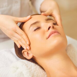 Woman looking peaceful while having her head massaged. 