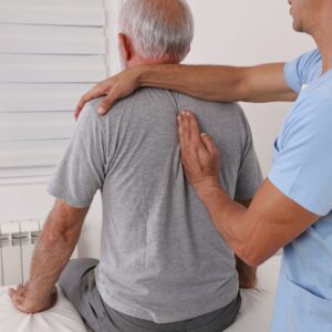 Older man getting a massage from a professional. 