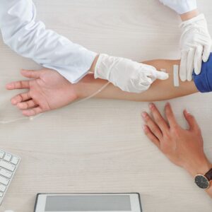 Professional inserting an IV into a patient's arm. 