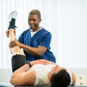 Physical therapist stretching a man's leg. 